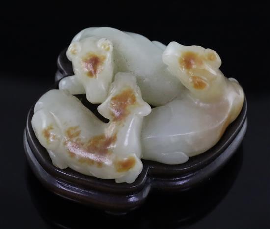 A Chinese pale celadon and russet jade group of three goats, 19th/20th century, 5cm, wood stand